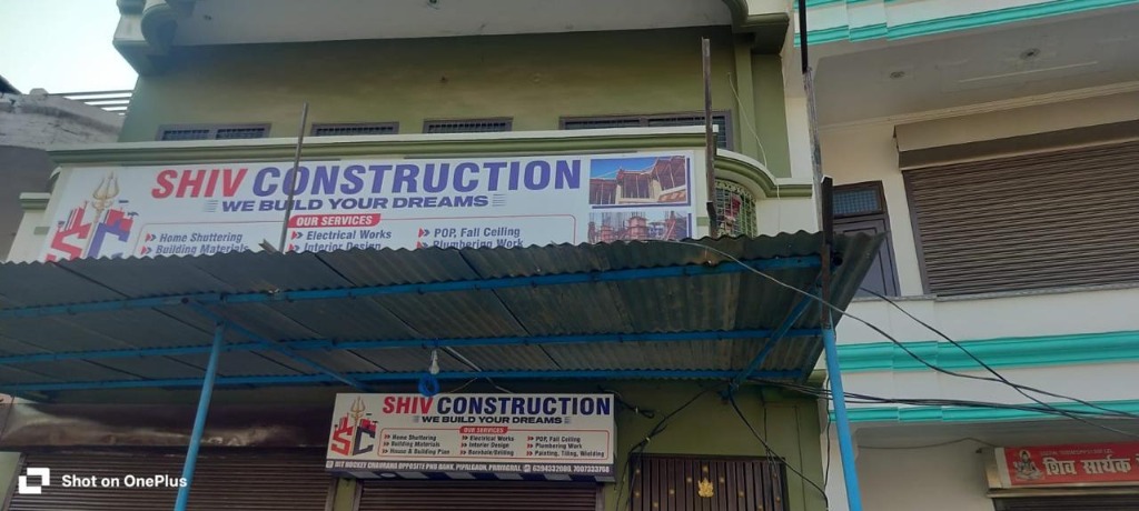 Close-up of Shiv Construction main entrance sign board listing construction services